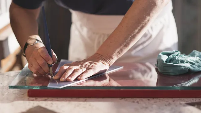 A piece of glass being marked so it can be the correct size needed for our showroom construction